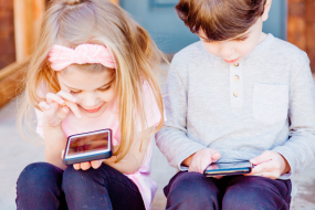 Mädchen und Junge mit Smartphones
